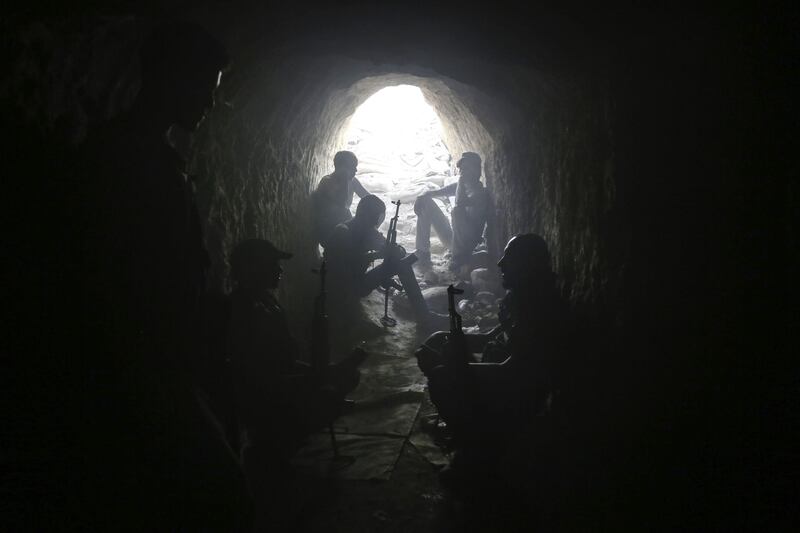 TOPSHOT - Syrian rebel fighters from the Faylaq al-Rahman brigade hold a position inside a tunnel in Ain Tarma, in the eastern Ghouta area, a rebel stronghold east of the capital Damascus, on August 16, 2017. 
Earlier in the week air strikes have pummelled rebel-held parts of the Jobar district of Damascus and the adjacent district of Ain Tarma. Eastern Ghouta is one of four "de-escalation zones" announced in May by opposition backer Turkey and regime allies Iran and Russia after talks in Kazakhstan. / AFP PHOTO / AMER ALMOHIBANY