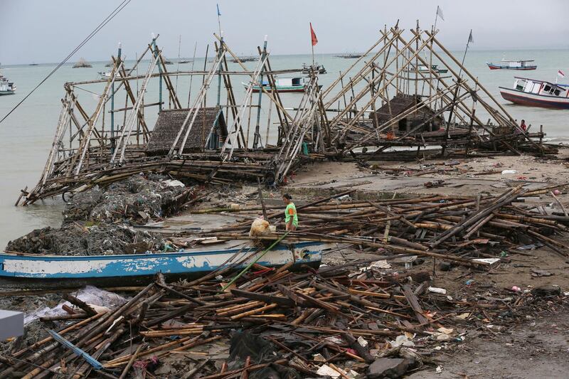 A woman walks amid debris in Sumur. AP Photo