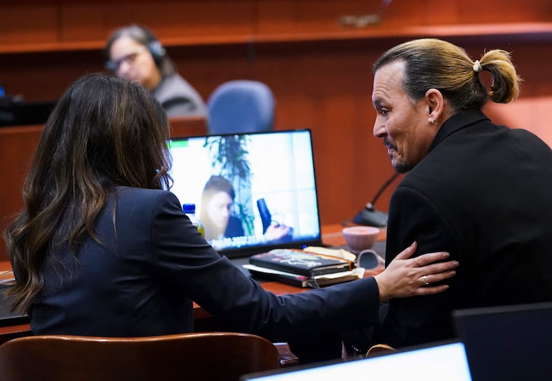 Depp speaks with his lawyer Camille Vasquez. AFP