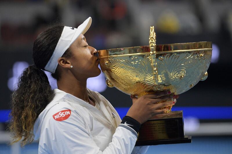 Naomi Osaka of Japan poses with the trophy after winning her women's singles final match against Ashleigh Barty of Australia at the China Open tennis tournament in Beijing on October 6, 2019. / AFP / NOEL CELIS
