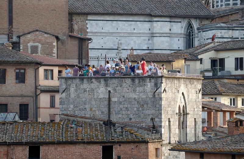 Spectators stand on a roof to get a good view of the race. Stefano Rellandini / Reuters