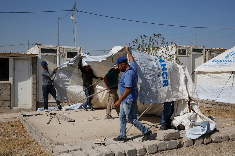 Workers set a tent in preparation to receive a few hundred Syrian refugees who have been newly displaced by the Turkish military operation in northeastern Syria, at the Bardarash camp, north of Mosul, Iraq. The camp used to host Iraqis displaced from Mosul during the fight against the Islamic State group and was closed two years ago. The U.N. says more around 160,000 Syrians have been displaced since the Turkish operation started last week, most of them internally in Syria. AP Photo