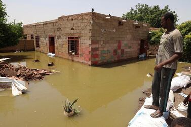 A man passes by the side of a flooded road in the town of Alkadro, about 20 kilometres north of the Sudanese capital Khartoum. AP