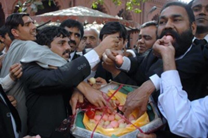 Pakistani lawyers share traditional sweets to celebrate the government decision to reinstate the chief justice Iftikhar Mohammed Chaudhry in Lahore, Pakistan.