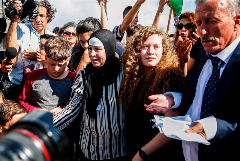 Palestinian activist and campaigner Ahed Tamimi stands alongside her father, mother, and brother upon her release from prison. AFP