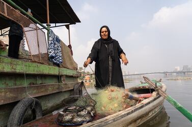 An Egyptian fisherwoman, Umm Reda, brings back a fishing cage loaded with fish. Each day's catch varies in size.