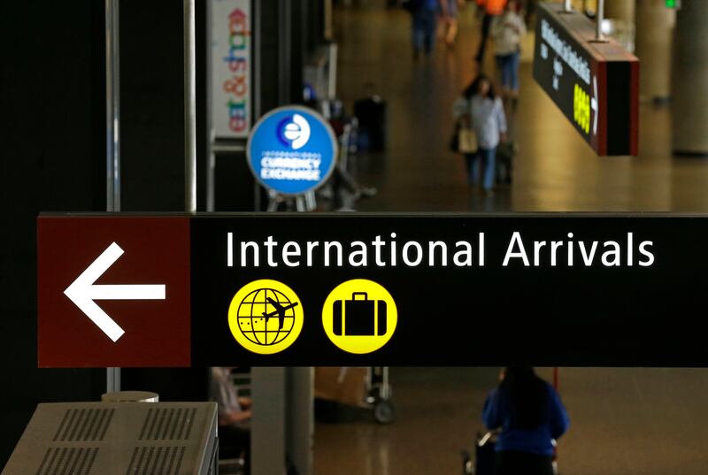 Travellers walk near a sign for international arrivals at Seattle-Tacoma International Airport on June 26, 2017. Ted S Warren / AP Photo