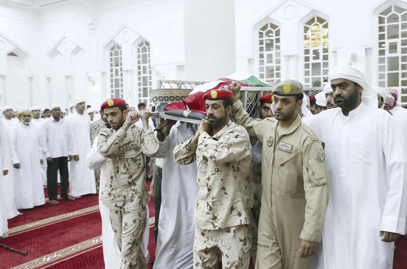 Men carry the body of Warrant Officer Sameer Mohammed Murad Abu Bakr into a mosque in Ajman before performing funeral prayers on Saturday. Wam