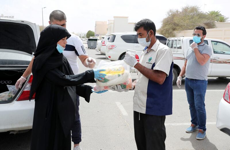AL AIN, UNITED ARAB EMIRATES , May 03 – 2020 :- Areej Jihad (left) distributing the raw food packets to the needy in Al Ain.  Areej Jihad is 40 years old and misses Iftar at home every day to help deliver food to the needy in Al Ain. (Pawan Singh / The National) For News. Story by Salam