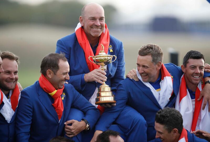 Team Europe captain Thomas Bjorn holds the trophy as they celebrate. Reuters