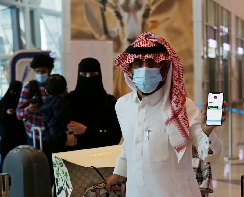 A Saudi traveller shows his vaccination certificate on his phone at a checkpoint in King Abdulaziz International Airport in Jiddah, Saudi Arabia. AP 