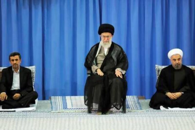 Iran's supreme leader Ayatollah Ali Khamenei, centre, officially endorses Hassan Rowhani, right, as the new country's president in Tehran. Mr Rouhani takes over from Mahmoud Ahmadinejad, left. khamenei.ir / AFP