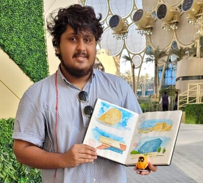 Zameen Mohammed with his book of Expo 2020 Dubai pavilion sketches, outside Al Wasl Dome on Saturday evening.