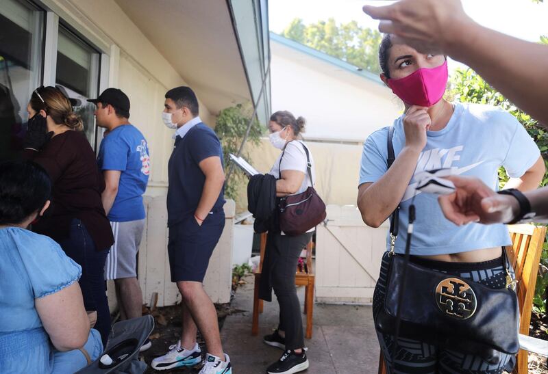 Family members and visitors gather outside patient Isaias Perez Yanez's room at Sharp Coronado Hospital, California. Covid-19 patients are not allowed to have visitors for safety reasons but family members and visitors are able to view and communicate with Yanez from outside the window.  Getty Images/AFP