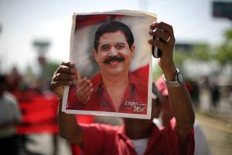 A supporter of the ousted Honduras' president holds a portrait of Mr Zelaya during  a march in San Pedro Sula, Honduras, on July 4 2009.