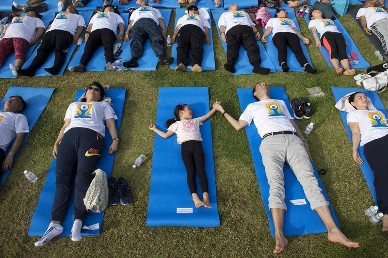 A man and child hold hands as they participate in a mass yoga session at the grounds of Chulalongkorn University in Bangkok. Romeo Gacad / AFP