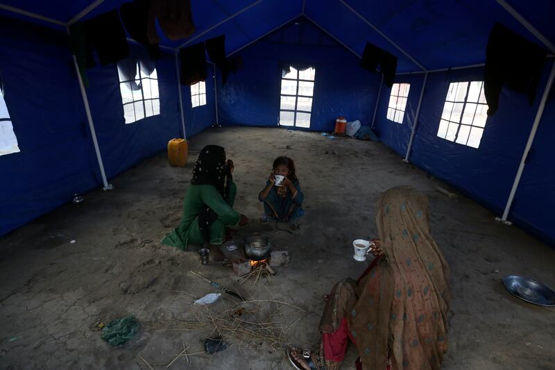 Flood victims drink tea at the UNHCR camp in Sukkur. AP