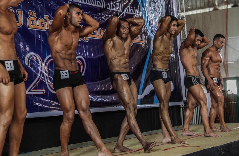 Palestinian bodybuilders flex their muscles as they compete during a bodybuilding and fitness championship, in Gaza City.  EPA