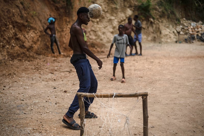 Youths play football in Port-au-Prince, Haiti. AP