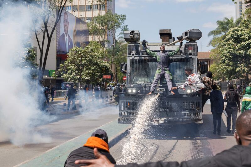 Protesters attempt to prevent police from using a water cannon. AFP