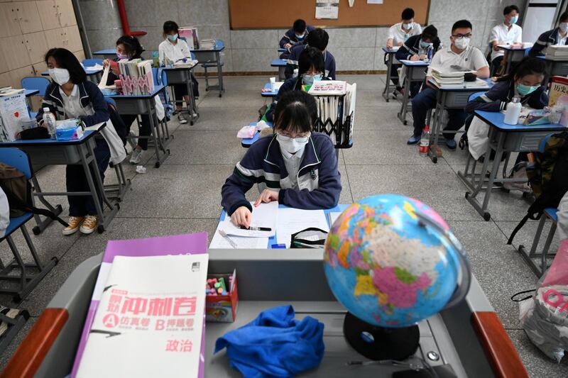 High school pupils wearing face masks are seen inside a classroom on their first day of returning to campus in Wuhan, Hubei province, China. Reuters