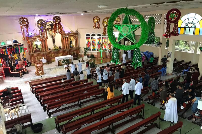 A Christmas Mass is held in a destroyed church in Alegria, in the Philippines, more than a week after Super Typhoon Rai devastated the area. AFP