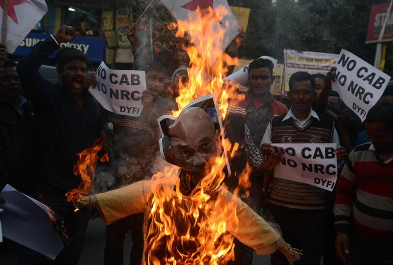 Left-wing activists of the Democratic Youth Federation of India shout slogans as they burn an effigy of India's Home Minister Amit Shah during a demonstration against the government's Citizenship Amendment Bill in Siliguri.  AFP