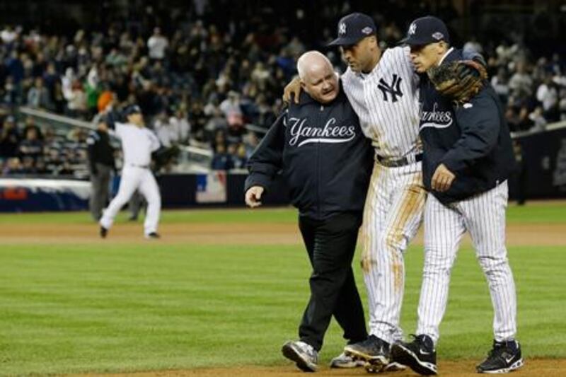 Yankees manager Joe Girardi and trainer Steve Donohue (l) help an injured Derek Jeter from the field