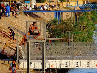 Fallujah residents rest on the bank of the Euphrates river. Imad Mohammed for The National 