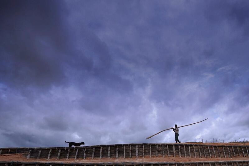 Rohingya man carries a bamboo pole at Kutupalong refugee camp in Ukhia on July 23, 2019. / AFP / MUNIR UZ ZAMAN
