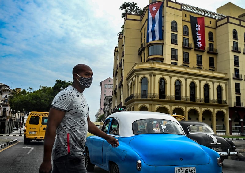 A man wearing a face mask crosses a street of Havana, the centre of the protests against economic hardship. AFP