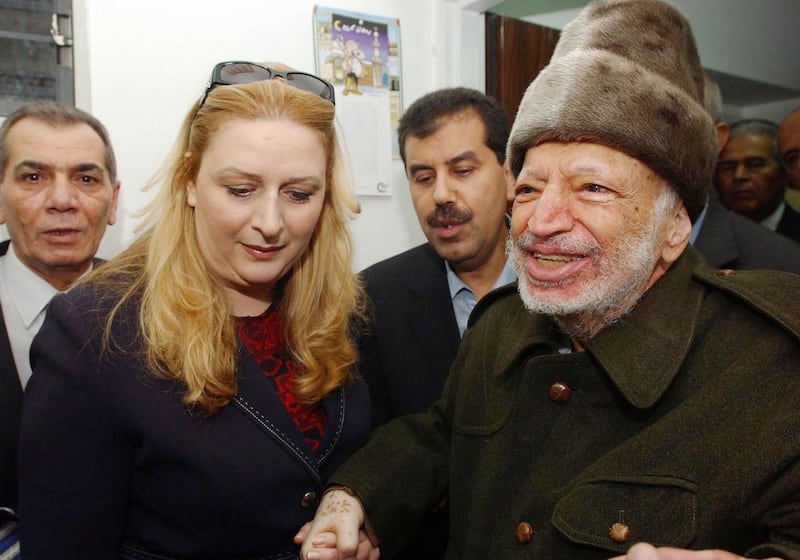 RAMALLAH, WEST BANK - OCTOBER 29:  In this handout picture from the Palestinian Press Office, Palestinian leader Yasser Arafat is led out of his compound in the West Bank, by his wife Suha Arafat, to board a helicopter bound for France in order to seek medical attention for an unknown illness on October 29, 2004 in Ramallah, West Bank. It is the first time Arafat has left his compound in more than two years of conflict with Israeli forces in the West Bank and Gaza. (Photo by Hussein Hussein/PPO via Getty Images) 