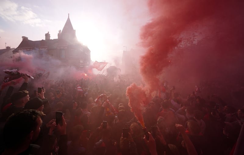 Liverpool fans greet their team bus. PA