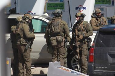 Members of the Royal Canadian Mounted Police (RCMP) tactical unit confer after the suspect in a deadly shooting rampage was neutralised at the Big Stop near Elmsdale, Nova Scotia, Canada, on April 19, 2020. AFP 