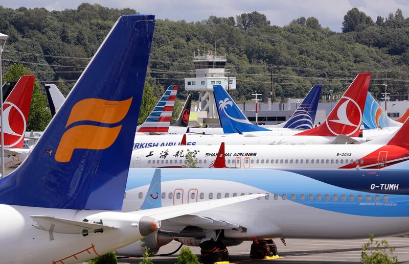 FILE - In this June 27, 2019, file photo, dozens of grounded Boeing 737 MAX airplanes crowd a parking area adjacent to Boeing Field in Seattle. Boeing hopes to resume deliveries of its 737 Max jet to airlines in December and win regulatory approval to restart commercial service with the plane in January. Boeing shares rose in midday trading Monday, Nov. 11. (AP Photo/Elaine Thompson, File)