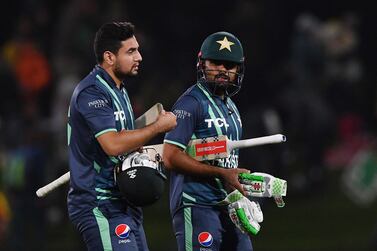 EDITORS NOTE: Graphic content / Pakistan's Babar Azam (R) and Haider Ali walk off the field after their victory in the second cricket match between New Zealand and Pakistan of the Twenty20 tri-series at Hagley Oval in Christchurch on October 8, 2022.  (Photo by Sanka Vidanagama  /  AFP)