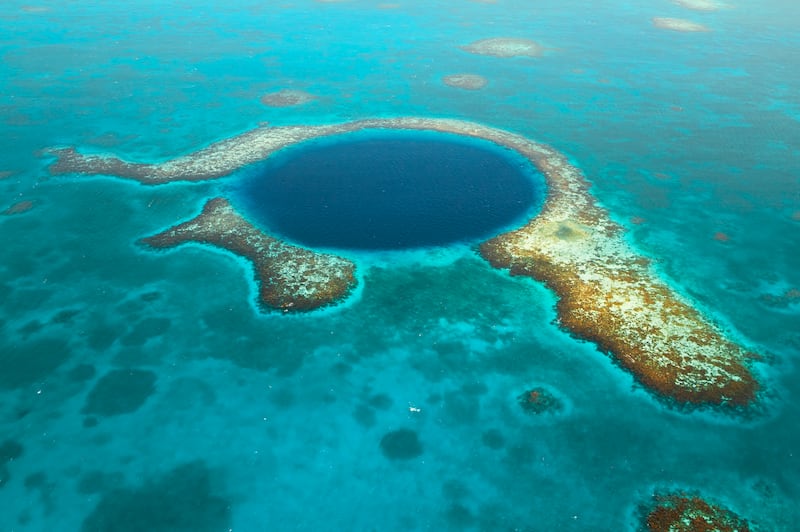 The Great Blue Hole in Belize was formed from an eroded limestone cave in the last ice age, and later flooded as the sea level rose. Getty Images