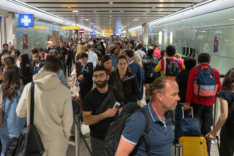 Travellers wait in a long queue to pass through the security check in 2022