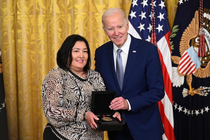 Mr Biden awards Jaclyn Sallee on behalf of Native America Calling. AFP