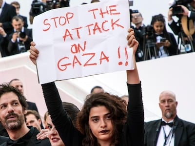 Lebanese actress Manal Issa, from "My Favorite Fabric," right, holds a sign that reads "Stop the Attack on Gaza" at the premiere of the film "Solo: A Star Wars Story" at the 71st international film festival, Cannes, southern France, Tuesday, May 15, 2018. Israeli soldiers shot and killed 59 Palestinians and wounded hundreds in mass protests on the Gaza border on Monday. Also with Issa are filmmakers Etienne Kallos, second left, and Gaya Jiji, second right. (Photo by Vianney Le Caer/Invision/AP)