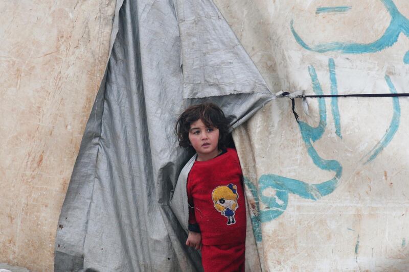 An internally displaced girl looks out from a tent in Azaz, Syria. REUTERS