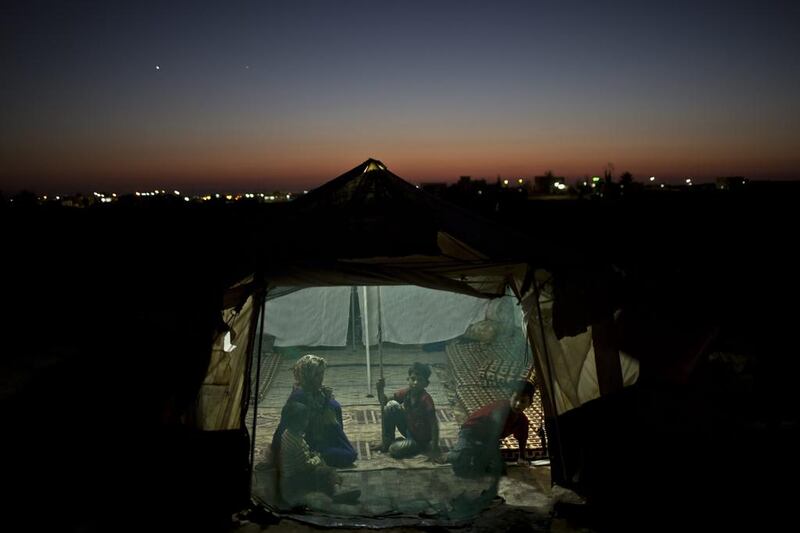 Syrian refugees inside a tent at an informal tented settlement near the Syrian border on the outskirts of Mafraq, Jordan. Muhammed Muheisen / AP Photo