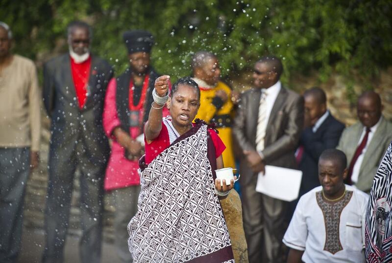 A traditional worshipper sprinkles holy water in prayer at dawn in Freedom Park in Pretoria. AP Photo