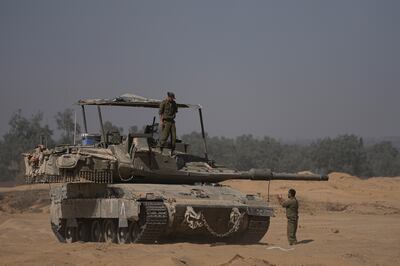 Israeli soldiers work on their tank near the border with Gaza in southern Israel. AP