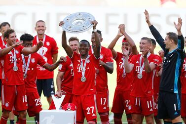 (FILES) This file photo taken on June 27, 2020 shows Bayern Munich's Austrian defender David Alaba (C) lifting the trophy as Bayern Munich players celebrate winning the German Bundesliga after the German first division Bundesliga football match VfL Wolfsburg v Bayern Munich in Wolfsburg, northern Germany. Defender David Alaba confirmed on February 16, 2021 he will leave Bayern Munich after 13 years at the club when his contract expires at the end of the season, but refused to name his next destination. / AFP / POOL / KAI PFAFFENBACH