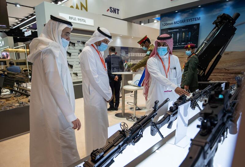 Abu Dhabi, United Arab Emirates, February 24, 2021.  Idex 2021 Day 4. Visitors look at the Korean made K-12C3 7.62mm machine gun at the SNT stand.Victor Besa / The NationalSection:  NA