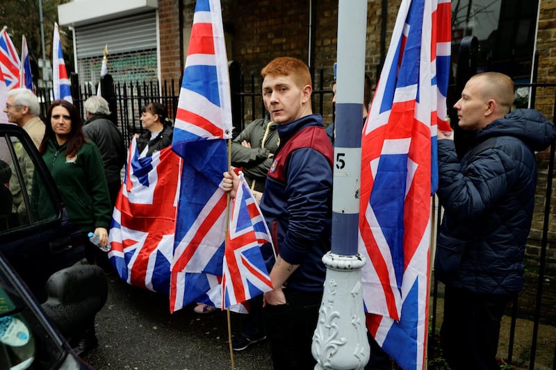 People hold the Union Flag whilst attending a Britain First rally as deputy leader Jayda Fransen (L) looks on, in Rochester, Britain November 15, 2014. Picture taken November 15, 2014.   REUTERS/Kevin Coombs