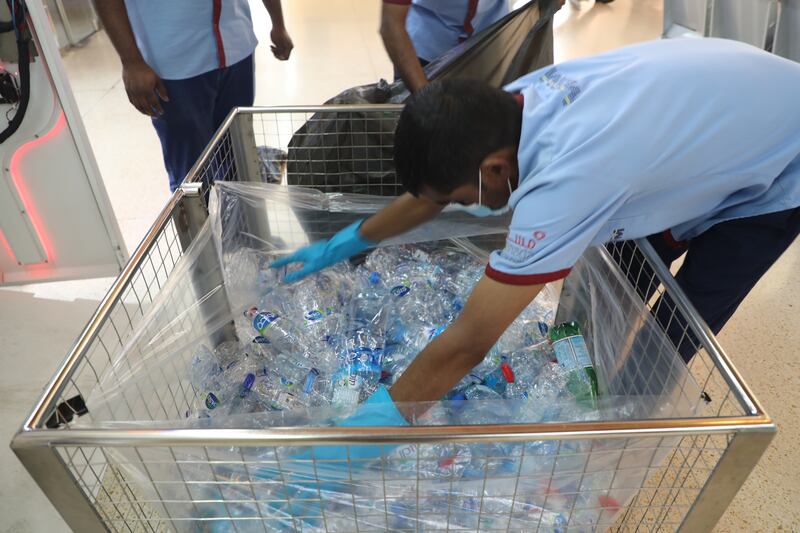 Workers collect plastic bottles for recycling. Nilanjana Gupta / The National