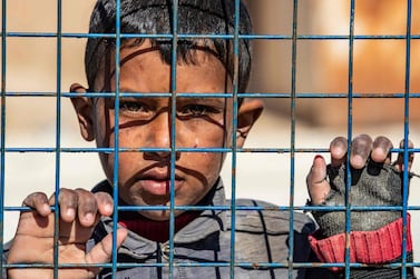 TOPSHOT - A boy awaits departure during the release of another group of Syrian families from the Kurdish-run al-Hol camp which holds suspected relatives of Islamic State (IS) group fighters, in Hasakeh governorate of northeastern Syria, on February 20, 2021. / AFP / Delil SOULEIMAN