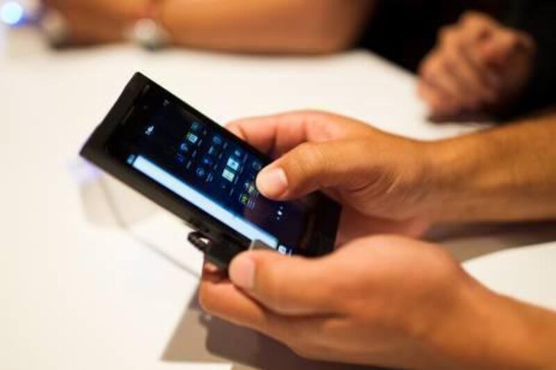 A man tries a Research In Motion Ltd. (RIM) BlackBerry 10 smartphone prototype at the BlackBerry Jam Asia developer conference in Bangkok, Thailand, on Thursday, Nov. 29, 2012. RIM gained after Goldman Sachs Group Inc. upgraded the stock to buy, saying the new BlackBerry 10 phones could help it return to profitability in fiscal 2014. Photographer: Brent Lewin/Bloomberg